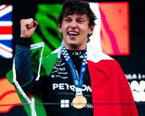 Kimi Antonelli celebrando sua vitória, com a bandeira da Itália nos ombros e atrás