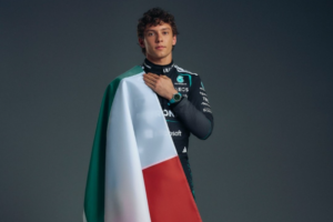 Andrea Kimi Antonelli da Mercedes-AMG Petronas envolto na bandeira italiana, com a mão sobre o peito.